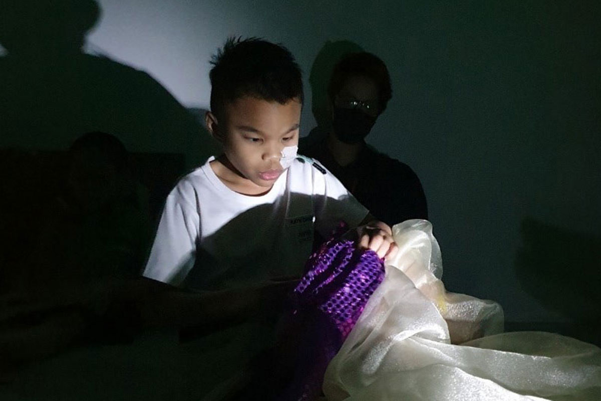 A young boy holding on to an art piece