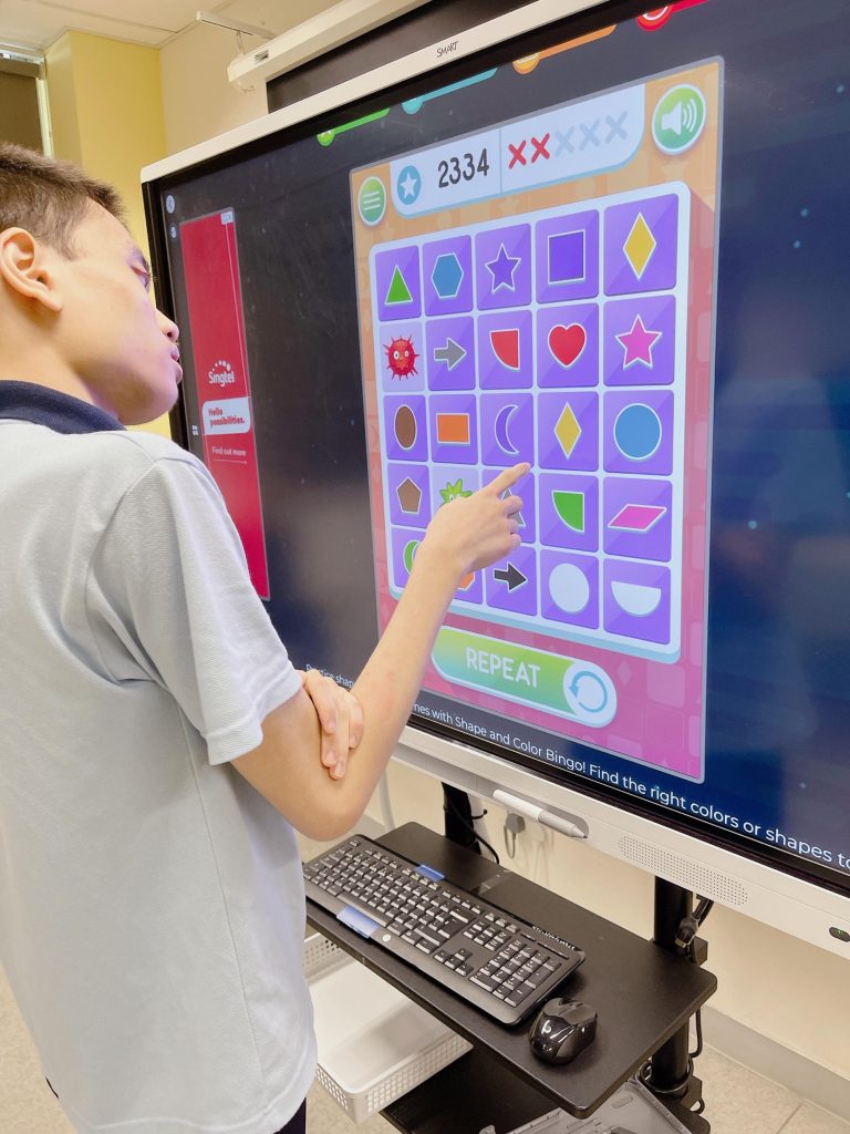 A boy in front of a huge screen solving a puzzle