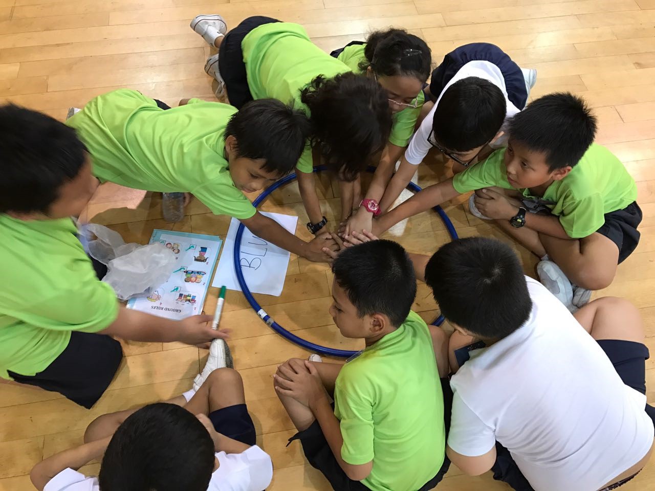 9 kids hovering in a circle in a court playing