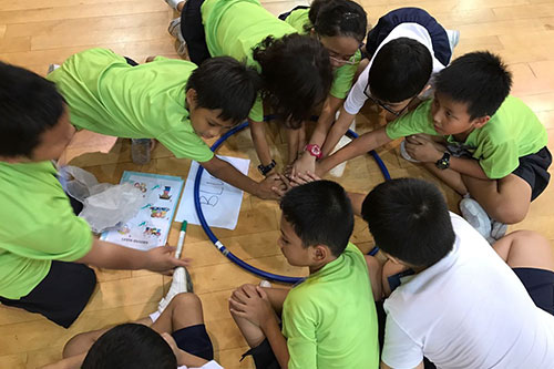 9 kids hovering in a circle in a court playing
