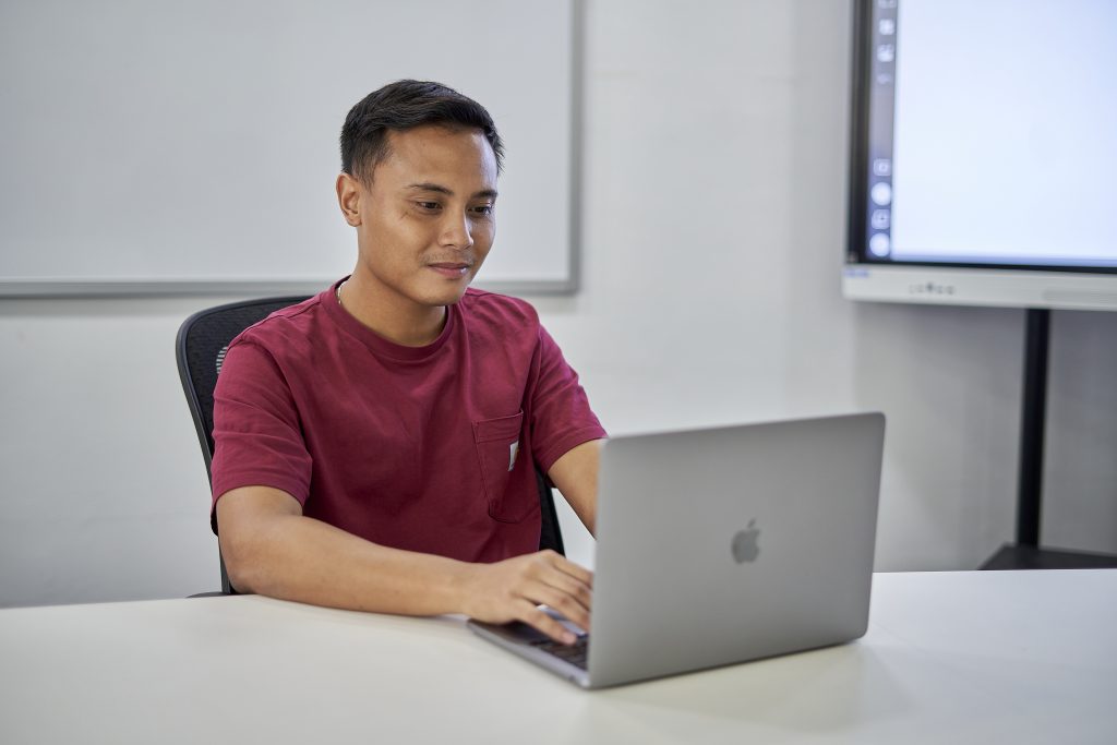 A guy on a work deskwith a macbook