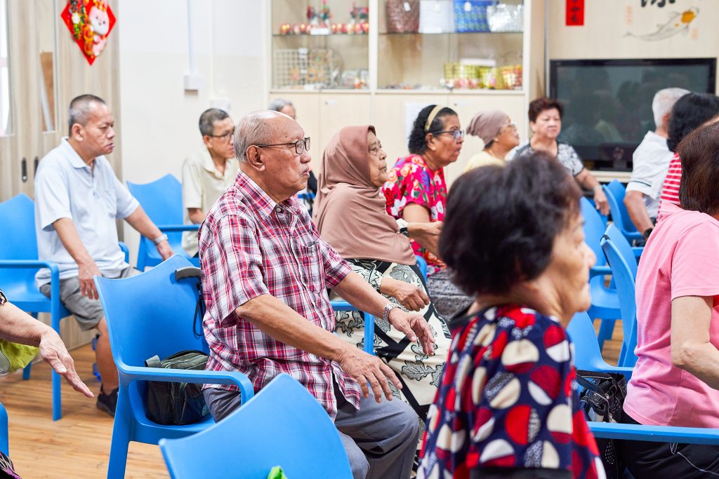 Group of elderlies sitting down in a room seems like a meeting