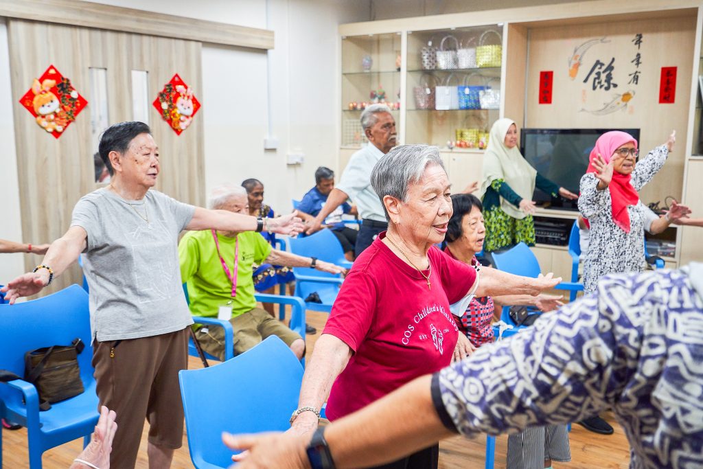 Group of elderlies in a room performing some exercises