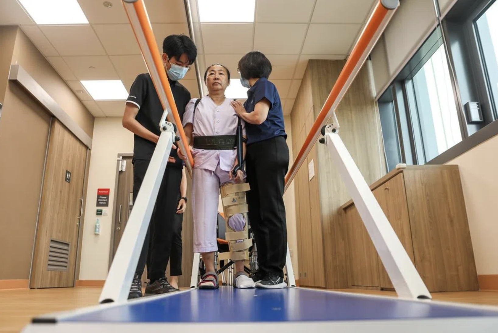 2 physiotherapist guy and woman assisting a patient indoor therapy