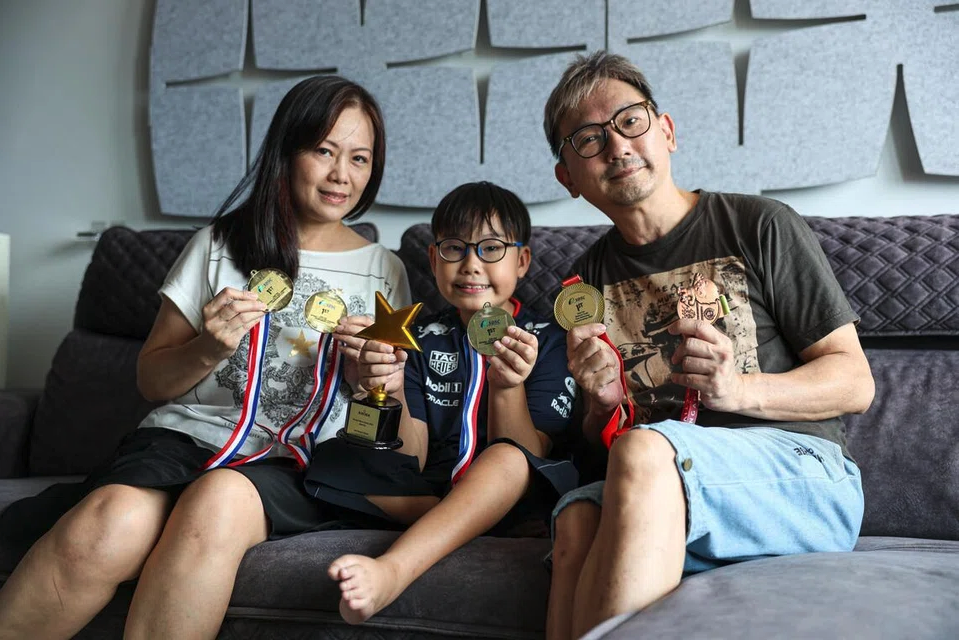 Primary 5 pupil Bryan Lee, who lives with spinal muscular atrophy, with his parents and his para swimming medals.